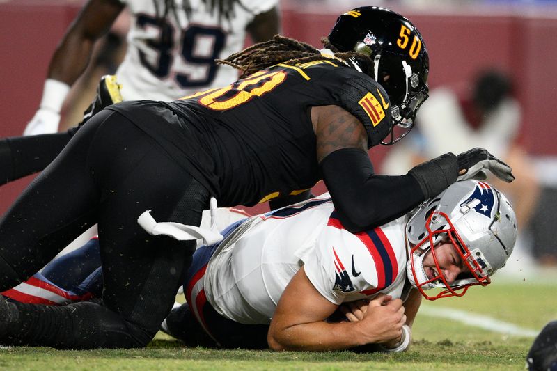 New England Patriots quarterback Drake Maye, bottom, is tackled after recovering his own fumble by Washington Commanders defensive end Andre Jones Jr. during the first half of a preseason NFL football game, Sunday, Aug. 25, 2024, in Landover, Md. (AP Photo/Nick Wass)