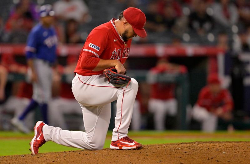 Sep 27, 2023; Anaheim, California, USA; Los Angeles Angels relief pitcher Carlos Estevez (53) kneels on the mound after giving up a two run home run to Texas Rangers center fielder Evan Carter (32) in the ninth inning at Angel Stadium. Mandatory Credit: Jayne Kamin-Oncea-USA TODAY Sports