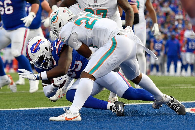 Buffalo Bills tight end Quintin Morris, left, scores a touchdown as Miami Dolphins linebacker Jordyn Brooks (20) defends during the second half of an NFL football game Sunday, Nov. 3, 2024, in Orchard Park, N.Y. (AP Photo/Adrian Kraus)