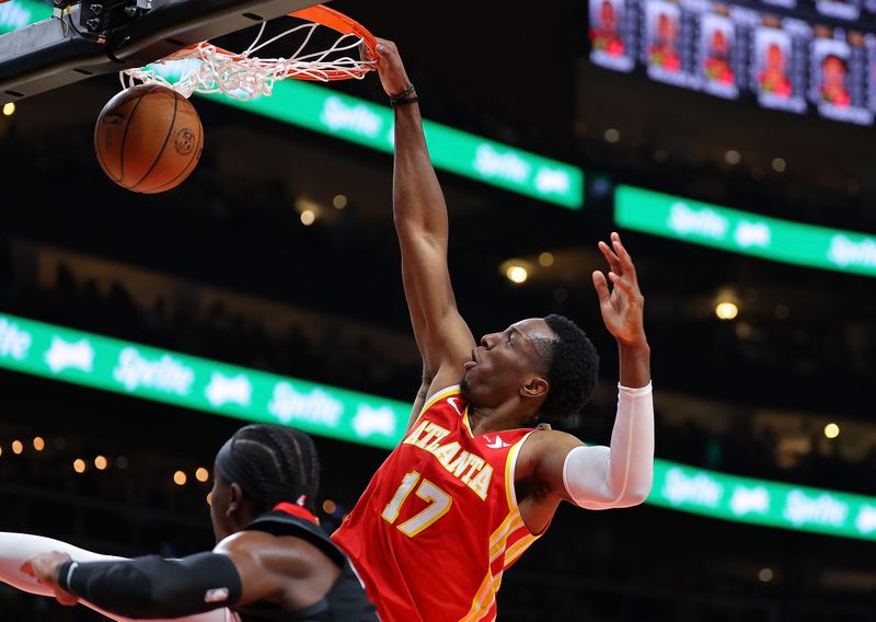 ATLANTA, GEORGIA - FEBRUARY 10:  Onyeka Okongwu #17 of the Atlanta Hawks draws a foul as he dunks against Aaron Holiday #0 of the Houston Rockets during the second quarter at State Farm Arena on February 10, 2024 in Atlanta, Georgia.  NOTE TO USER: User expressly acknowledges and agrees that, by downloading and/or using this photograph, user is consenting to the terms and conditions of the Getty Images License Agreement.  (Photo by Kevin C. Cox/Getty Images)