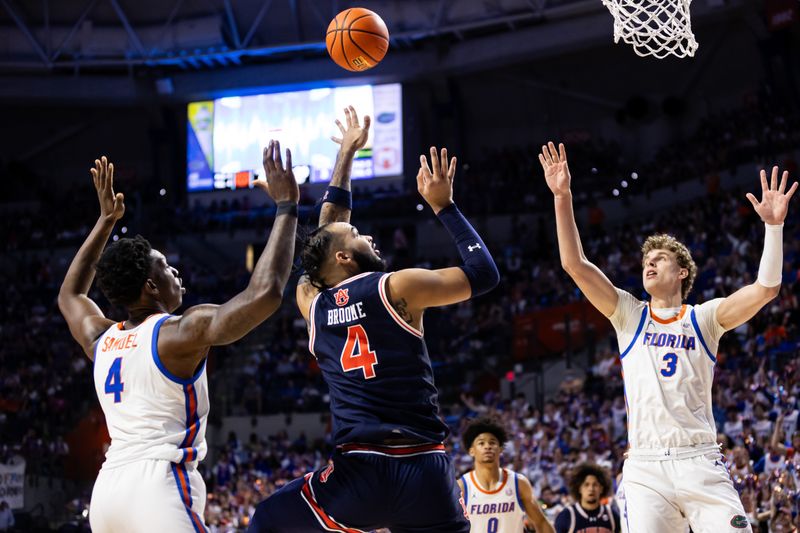 Feb 10, 2024; Gainesville, Florida, USA; Auburn Tigers forward Johni Broome (4) attempts a shot over Florida Gators forward Tyrese Samuel (4) and center Micah Handlogten (3) during the first half at Exactech Arena at the Stephen C. O'Connell Center. Mandatory Credit: Matt Pendleton-USA TODAY Sports