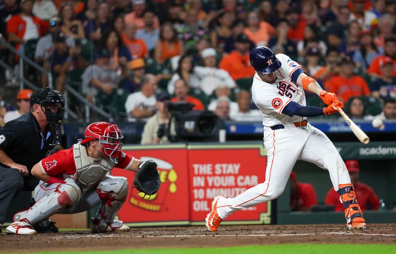 Sep 21, 2024; Houston, Texas, USA; Houston Astros first baseman Victor Caratini (17) hits a three-run home run against the Los Angeles Angels in the third inning at Minute Maid Park. Mandatory Credit: Thomas Shea-Imagn Images