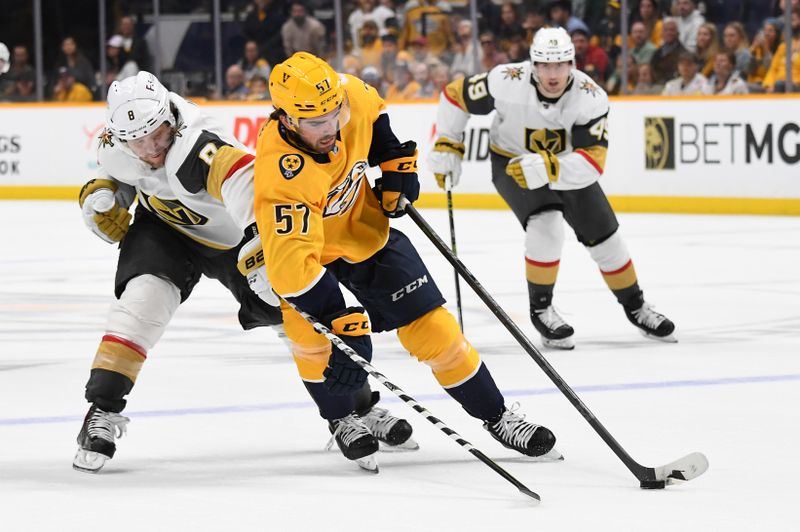 Apr 4, 2023; Nashville, Tennessee, USA; Nashville Predators defenseman Dante Fabbro (57) handles the puck against Vegas Golden Knights right wing Phil Kessel (8) during the second period at Bridgestone Arena. Mandatory Credit: Christopher Hanewinckel-USA TODAY Sports