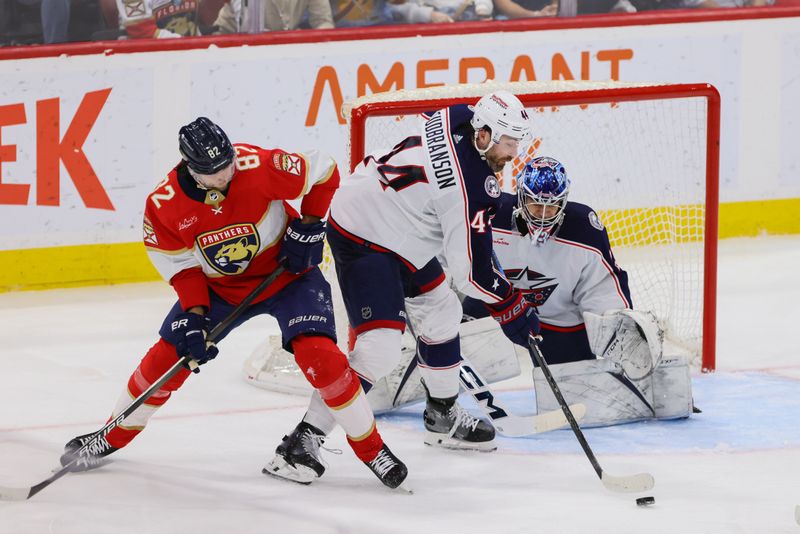 Apr 11, 2024; Sunrise, Florida, USA; Columbus Blue Jackets defenseman Erik Gudbranson (44) moves the puck against Florida Panthers center Kevin Stenlund (82) during the third period at Amerant Bank Arena. Mandatory Credit: Sam Navarro-USA TODAY Sports