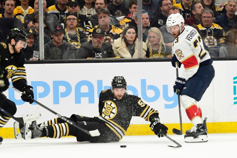 May 17, 2024; Boston, Massachusetts, USA; Boston Bruins defenseman Andrew Peeke (52) tries to gain control of the puck from Florida Panthers center Carter Verhaeghe (23) during the second period in game six of the second round of the 2024 Stanley Cup Playoffs at TD Garden. Mandatory Credit: Bob DeChiara-USA TODAY Sports