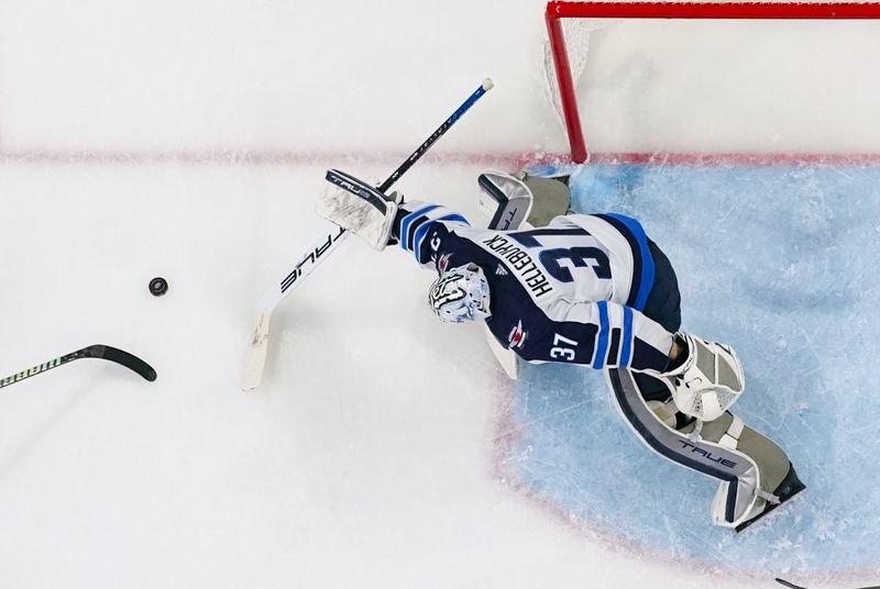 Mar 2, 2024; Raleigh, North Carolina, USA; Winnipeg Jets goaltender Connor Hellebuyck (37) makes a save against the Carolina Hurricanes during the second period at PNC Arena. Mandatory Credit: James Guillory-USA TODAY Sports