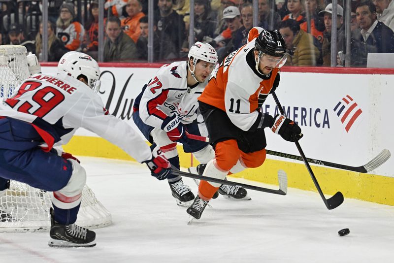 Feb 3, 2026; Philadelphia, Pennsylvania, USA; Philadelphia Flyers right wing Travis Konecny (11) carries the puck against Washington Capitals center Hendrix Lapierre (29) and left wing Anthony Beauvillier (72) during the third period at Xfinity Mobile Arena. Mandatory Credit: Eric Hartline-Imagn Images