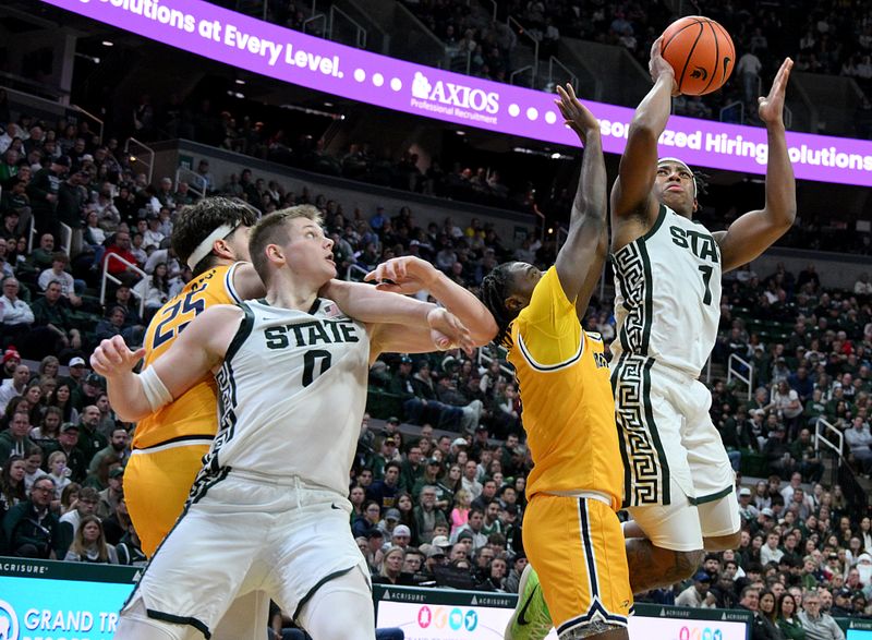 Dec 16, 2025; East Lansing, Michigan, USA; Michigan State Spartans guard Jeremy Fears Jr. (1) puts up a jump shot as teammate Michigan State Spartans forward Jaxon Kohler (0) battles for position with Toledo Rockets center Austin Parks (25) during the second half at Jack Breslin Student Events Center. Mandatory Credit: Dale Young-Imagn Images