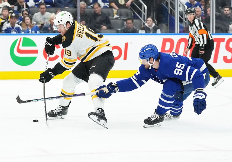 Nov 5, 2024; Toronto, Ontario, CAN; Boston Bruins center John Beecher (19) and Toronto Maple Leafs defenseman Oliver Ekman-Larsson (95) battle for the puck during the second period at Scotiabank Arena. Mandatory Credit: Nick Turchiaro-Imagn Imagess