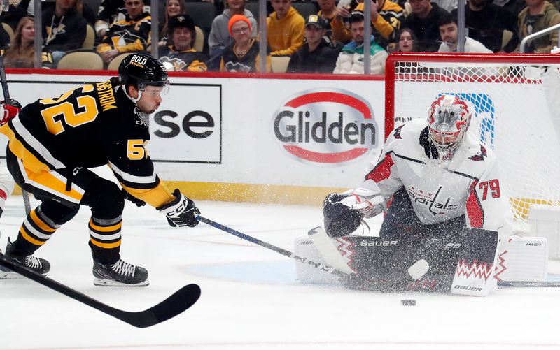 Mar 7, 2024; Pittsburgh, Pennsylvania, USA; Washington Capitals goaltender Charlie Lindgren (79) makes a save against Pittsburgh Penguins right wing Emil Bemstrom (52) during the first period at PPG Paints Arena. Mandatory Credit: Charles LeClaire-USA TODAY Sports