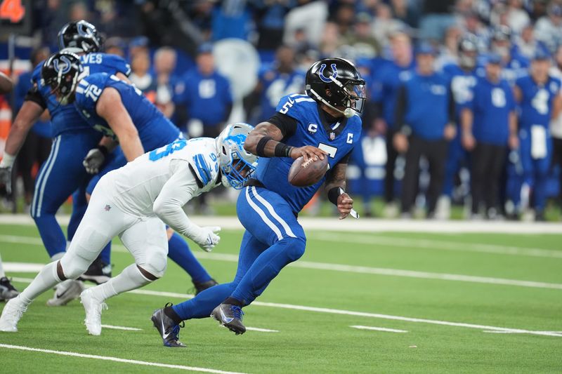 Indianapolis Colts quarterback Anthony Richardson (5) pulls away from Detroit Lions defensive end Za'Darius Smith (99) during the second half of an NFL football game, Sunday, Nov. 24, 2024, in Indianapolis. (AP Photo/Michael Conroy)