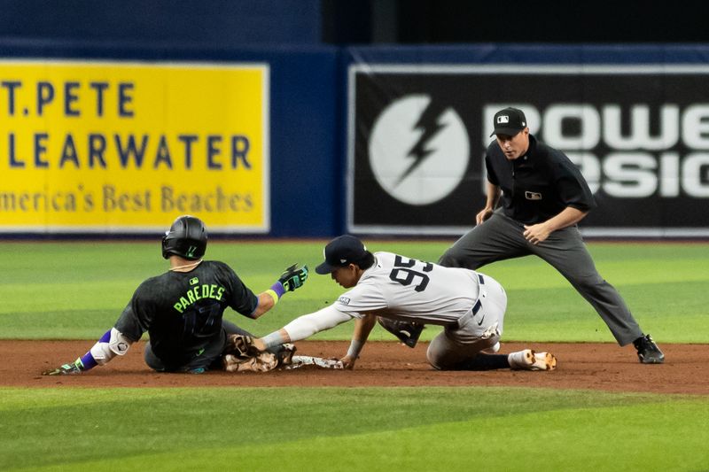 May 11, 2024; St. Petersburg, Florida, USA; Tampa Bay Rays third base Isaac Paredes (17) slides into second base against New York Yankees third base Oswaldo Cabrera (95) during the sixth inning at Tropicana Field. Mandatory Credit: Matt Pendleton-USA TODAY Sports
