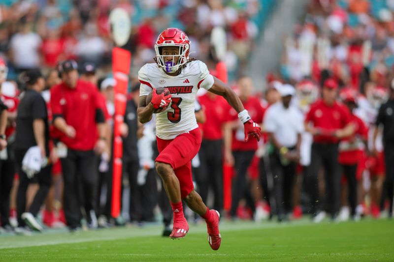 Nov 18, 2023; Miami Gardens, Florida, USA; Louisville Cardinals wide receiver Kevin Coleman (3) runs with the football for a touchdown against the Miami Hurricanes during the fourth quarter at Hard Rock Stadium. Mandatory Credit: Sam Navarro-USA TODAY Sports