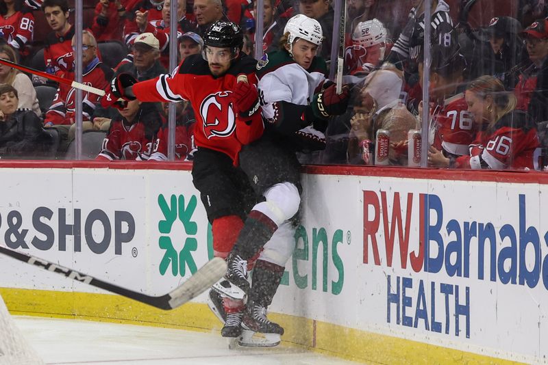 Oct 13, 2023; Newark, New Jersey, USA; New Jersey Devils defenseman Kevin Bahl (88) hits Arizona Coyotes center Logan Cooley (92) during the first period at Prudential Center. Mandatory Credit: Ed Mulholland-USA TODAY Sports