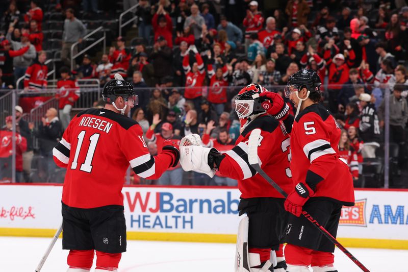 Oct 24, 2025; Newark, New Jersey, USA; New Jersey Devils right wing Stefan Noesen (11), defenseman Brenden Dillon (5) and goaltender Jake Allen (34) celebrate the Devils win over the San Jose Sharks at Prudential Center. Mandatory Credit: Ed Mulholland-Imagn Images