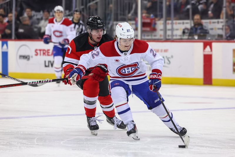 Jan 17, 2024; Newark, New Jersey, USA; Montreal Canadiens right wing Cole Caufield (22) skates with the puck while being defended by New Jersey Devils defenseman Simon Nemec (17) during the first period at Prudential Center. Mandatory Credit: Ed Mulholland-USA TODAY Sports