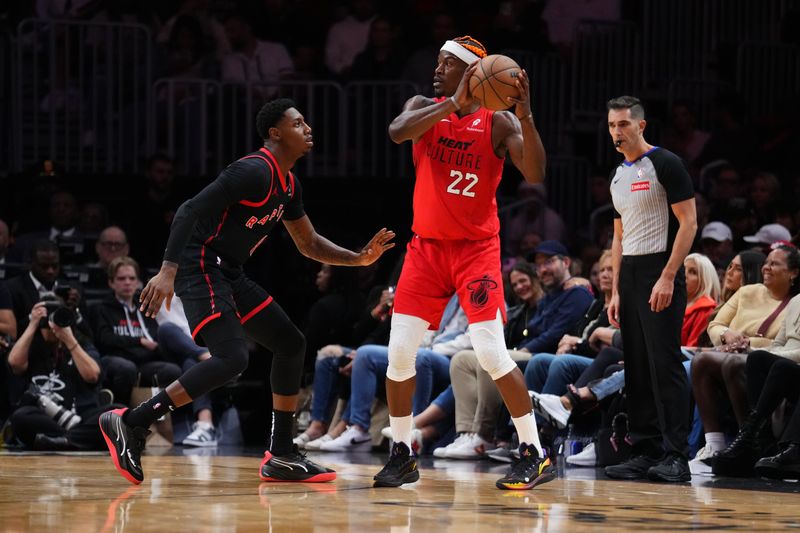 MIAMI, FLORIDA - DECEMBER 12: Jimmy Butler #22 of the Miami Heat looks to throw a pass against RJ Barrett #9 of the Toronto Raptors during the third quarter at Kaseya Center on December 12, 2024 in Miami, Florida. NOTE TO USER: User expressly acknowledges and agrees that, by downloading and or using this Photograph, user is consenting to the terms and conditions of the Getty Images License Agreement. (Photo by Rich Storry/Getty Images)