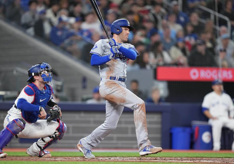 Apr 26, 2024; Toronto, Ontario, CAN; Los Angeles Dodgers first base Freddie Freeman (5) hits an RBI single against the Toronto Blue Jays during the third inning at Rogers Centre. Mandatory Credit: Nick Turchiaro-USA TODAY Sports