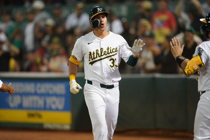 Jul 19, 2024; Oakland, California, USA; Oakland Athletics center fielder JJ Bleday (33) is congratulated by teammates after hitting a two-run home run against the Los Angeles Angels in the sixth inning at Oakland-Alameda County Coliseum. Mandatory Credit: Cary Edmondson-USA TODAY Sports