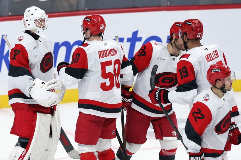 Nov 21, 2025; Winnipeg, Manitoba, CAN; Carolina Hurricanes celebrate their victory over the Winnipeg Jets at Canada Life Centre. Mandatory Credit: James Carey Lauder-Imagn Images
