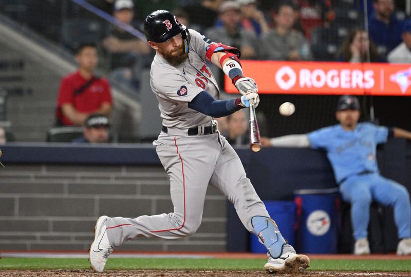 Sep 24, 2024; Toronto, Ontario, CAN;  Boston Red Sox shortstop Trevor Story (10) hits an RBI single against the Toronto Blue Jays in the tenth inning at Rogers Centre. Mandatory Credit: Dan Hamilton-Imagn Images