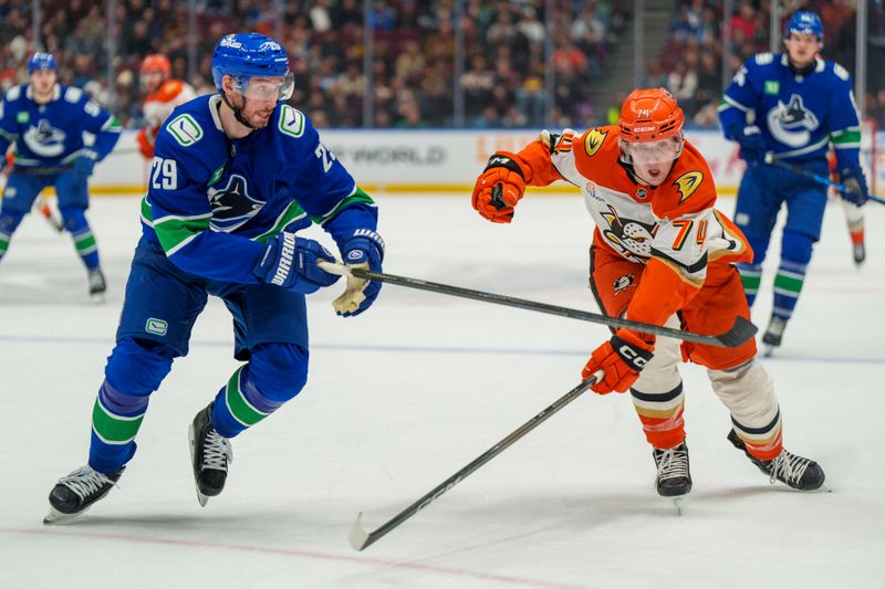 Jan 29, 2026; Vancouver, British Columbia, CAN;  Vancouver Canucks defenseman Marcus Pettersson (29) and Anaheim Ducks Defenseman Ian Moore (74) chase the puck in the second period at Rogers Arena. Mandatory Credit: Christopher Morris-Imagn Images