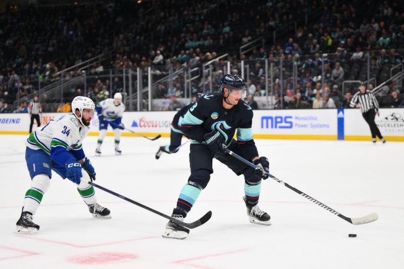 Nov 24, 2023; Seattle, Washington, USA; Seattle Kraken defenseman Brian Dumoulin (8) plays the puck while defended by Vancouver Canucks left wing Phillip Di Giuseppe (34) during the third period at Climate Pledge Arena. Mandatory Credit: Steven Bisig-USA TODAY Sports