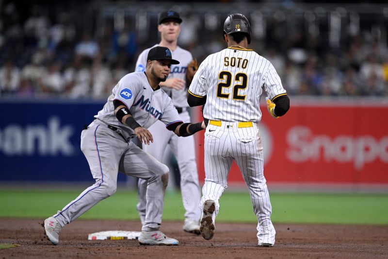 Aug 21, 2023; San Diego, California, USA; San Diego Padres left fielder Juan Soto (22) is tagged out after by Miami Marlins second baseman Luis Arraez (left) being caught in a rundown during the second inning at Petco Park. Mandatory Credit: Orlando Ramirez-USA TODAY Sports