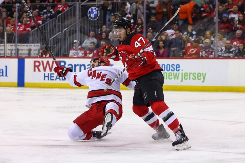 Nov 21, 2024; Newark, New Jersey, USA; New Jersey Devils center Paul Cotter (47) delivers a hit against the Carolina Hurricanes during the second period at Prudential Center. Mandatory Credit: Ed Mulholland-Imagn Images