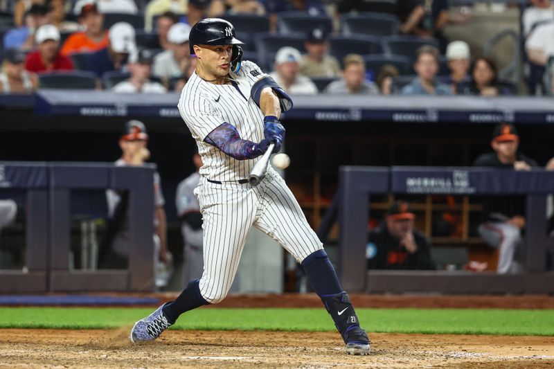 Jun 19, 2024; Bronx, New York, USA;  New York Yankees designated hitter Giancarlo Stanton (27) hits a three-run home run in the seventh inning against the Baltimore Orioles at Yankee Stadium. Mandatory Credit: Wendell Cruz-USA TODAY Sports