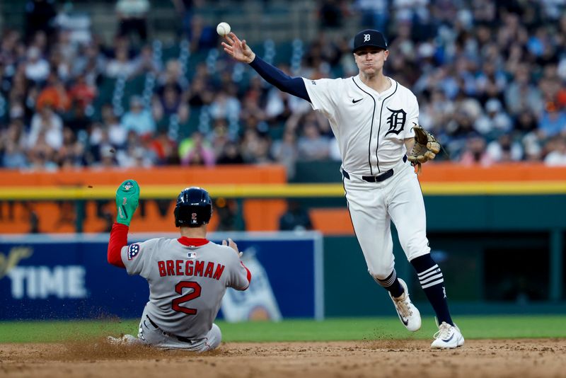 May 14, 2025; Detroit, Michigan, USA;  Detroit Tigers shortstop Trey Sweeney (27) makes a throw to first to complete a double play as Boston Red Sox third baseman Alex Bregman (2) slide onto second in the seventh inning at Comerica Park. Mandatory Credit: Rick Osentoski-Imagn Images