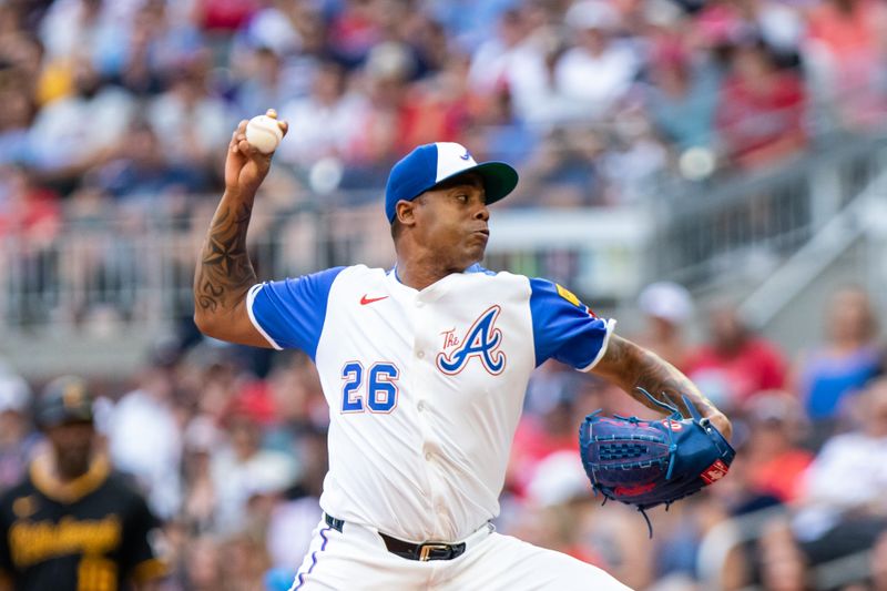 Jun 29, 2024; Cumberland, Georgia, USA; Atlanta Braves pitcher Raisel Iglesias (26) pitches against the Pittsburgh Pirates during the eighth inning at Truist Park. Mandatory Credit: Jordan Godfree-USA TODAY Sports