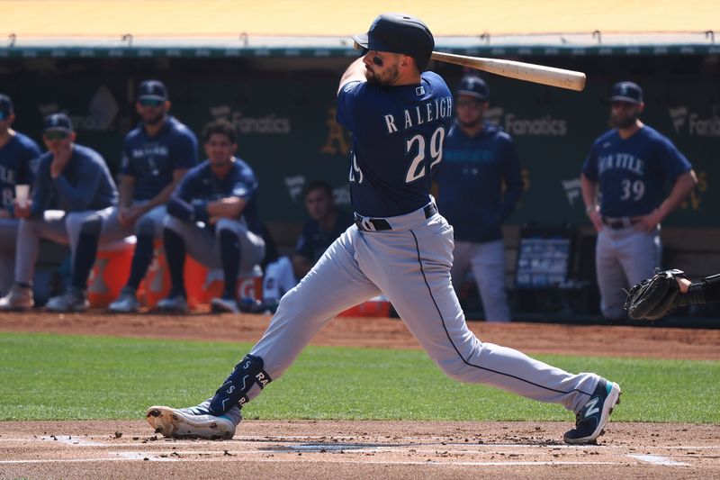 Sep 20, 2023; Oakland, California, USA; Seattle Mariners catcher Cal Raleigh (29) hits a double against the Oakland Athletics during the first inning at Oakland-Alameda County Coliseum. Mandatory Credit: Kelley L Cox-USA TODAY Sports