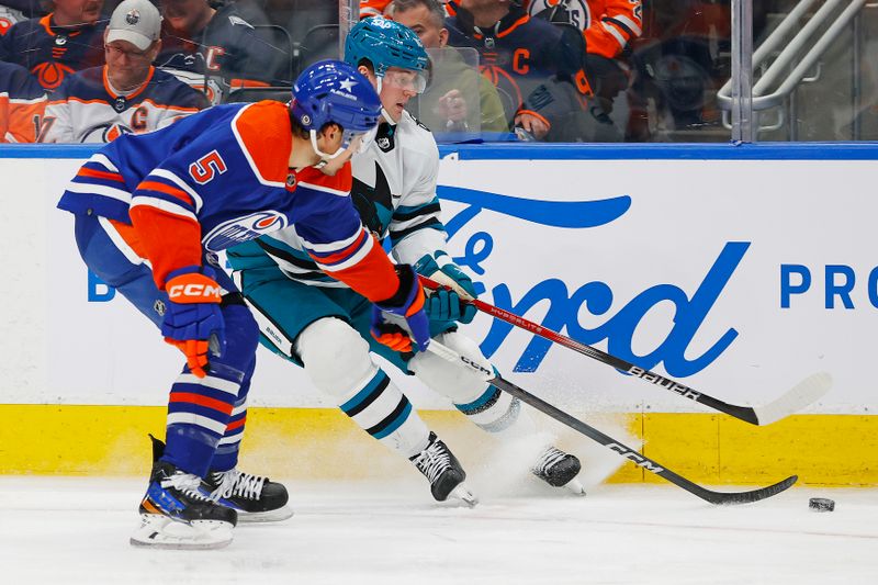 Apr 15, 2024; Edmonton, Alberta, CAN; Edmonton Oilers defensemen Cody Ceci (5) and San Jose Sharks forward Klim Kostin (10) battle for a loose puck during the second period at Rogers Place. Mandatory Credit: Perry Nelson-USA TODAY Sports