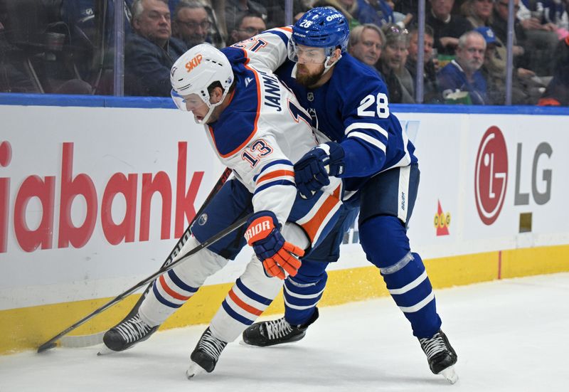 Nov 16, 2024; Toronto, Ontario, CAN;  Toronto Maple Leafs defenseman Jani Hakanpaa (28) covers Edmonton Oilers forward Mattias Janmark (13) in the second period at Scotiabank Arena. Mandatory Credit: Dan Hamilton-Imagn Images