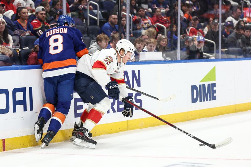 Mar 16, 2025; Elmont, New York, USA;  New York Islanders defenseman Noah Dobson (8) and Florida Panthers center Anton Lundell (15) battle for control of the puck in the first period at UBS Arena. Mandatory Credit: Wendell Cruz-Imagn Images