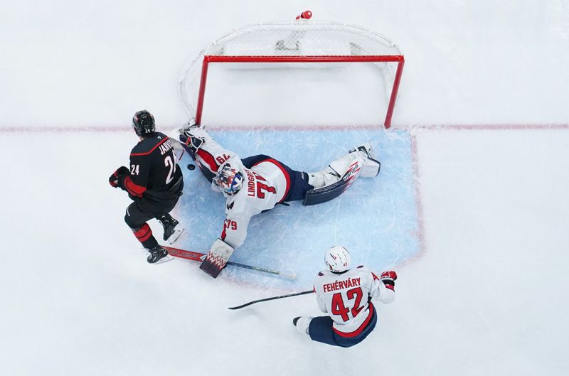 Nov 3, 2024; Raleigh, North Carolina, USA;  Washington Capitals goaltender Charlie Lindgren (79) stops the scoring attempt by Carolina Hurricanes center Seth Jarvis (24) during the second period at Lenovo Center. Mandatory Credit: James Guillory-Imagn Images