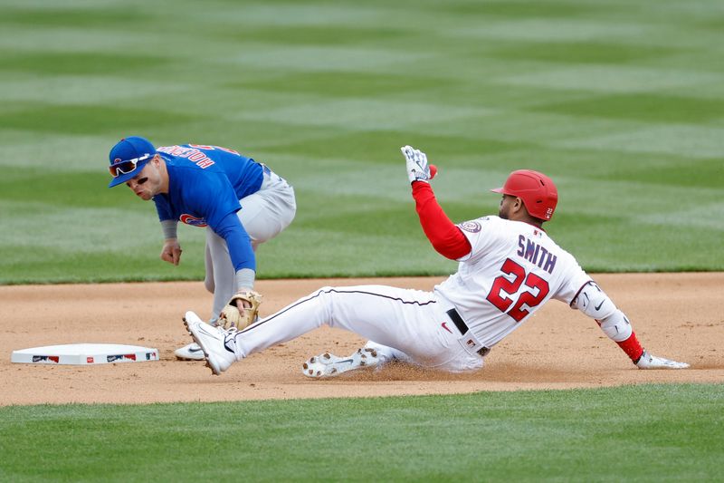 May 4, 2023; Washington, District of Columbia, USA; Washington Nationals first baseman Dominic Smith (22) is tagged out at second base by Chicago Cubs second baseman Nico Hoerner (2) after attempting to stretch a hit to a double during the seventh inning at Nationals Park. Mandatory Credit: Geoff Burke-USA TODAY Sports