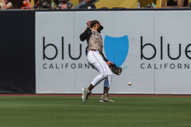 Sep 8, 2024; San Diego, California, USA; San Diego Padres right fielder Fernando Tatis Jr. (23) loses a fly ball in the sun resulting in a double to San Francisco Giants center fielder Heliot Ramos (17) during the fourth inning at Petco Park. Mandatory Credit: Chadd Cady-Imagn Images