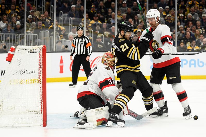 Apr 16, 2024; Boston, Massachusetts, USA;  Boston Bruins left wing James van Riemsdyk (21) and Ottawa Senators defenseman Jake Sanderson (85) battle in front of goaltender Anton Forsberg (31) during the third period at TD Garden. Mandatory Credit: Bob DeChiara-USA TODAY Sports