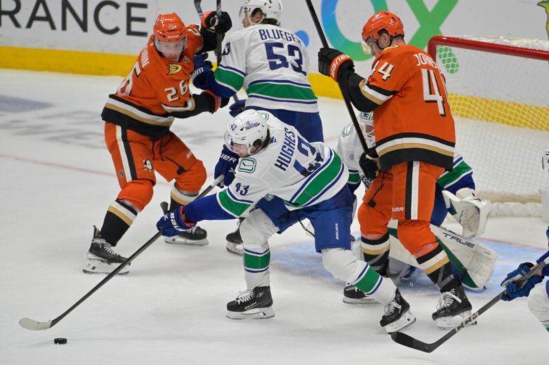 Nov 5, 2024; Anaheim, California, USA; Vancouver Canucks defenseman Quinn Hughes (43) keeps the puck away from Anaheim Ducks left wing Ross Johnston (44) in the first period at Honda Center. Mandatory Credit: Jayne Kamin-Oncea-Imagn Images