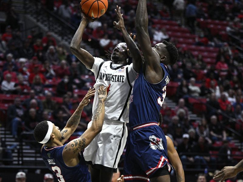 Jan 3, 2024; San Diego, California, USA; San Diego State Aztecs forward Jay Pal (4) shoots the ball while defended by Fresno State Bulldogs forward Pierre Geneste Jr. (34) and guard Isaiah Hill (3) during the second half at Viejas Arena. Mandatory Credit: Orlando Ramirez-USA TODAY Sports 