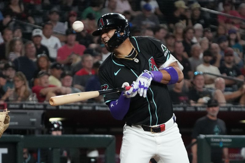 Aug 14, 2024; Phoenix, Arizona, USA; Arizona Diamondbacks outfielder Lourdes Gurriel Jr. (12) reacts after being hit by a pitch against the Colorado Rockies in the sixth inning at Chase Field. Mandatory Credit: Rick Scuteri-USA TODAY Sports