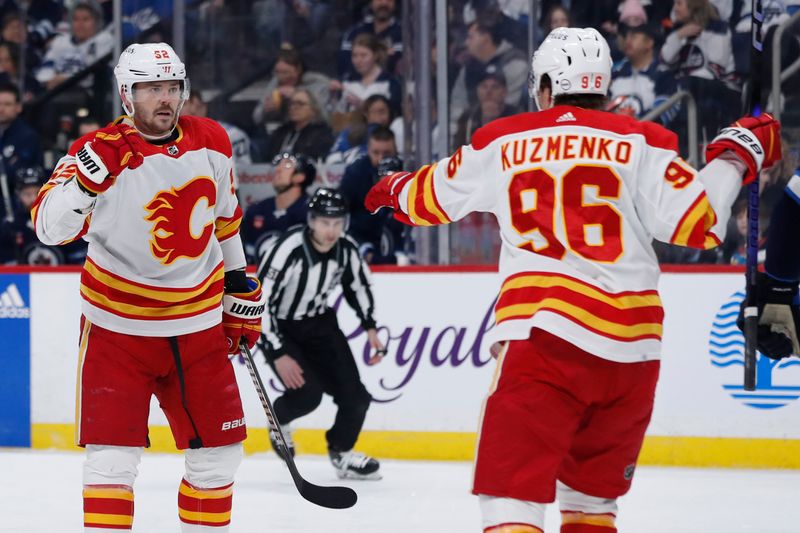 Apr 4, 2024; Winnipeg, Manitoba, CAN; Calgary Flames defenseman MacKenzie Weegar (52) celebrates his first period goal with Calgary Flames left wing Andrei Kuzmenko (96) against the Winnipeg Jets at Canada Life Centre. Mandatory Credit: James Carey Lauder-USA TODAY Sports