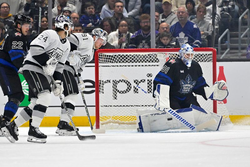 Jan 2, 2024; Los Angeles, California, USA; Los Angeles Kings center Phillip Danault (24) and right wing Carl Grundstrom (91) wait for a rebound as Toronto Maple Leafs goaltender Martin Jones (31) makes a save in the first period at Crypto.com Arena. Mandatory Credit: Jayne Kamin-Oncea-USA TODAY Sports