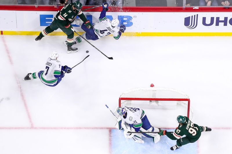 Dec 3, 2024; Saint Paul, Minnesota, USA; Minnesota Wild center Joel Eriksson Ek (14) checks Vancouver Canucks defenseman Noah Juulsen (47) during the third period at Xcel Energy Center. Mandatory Credit: Matt Krohn-Imagn Images