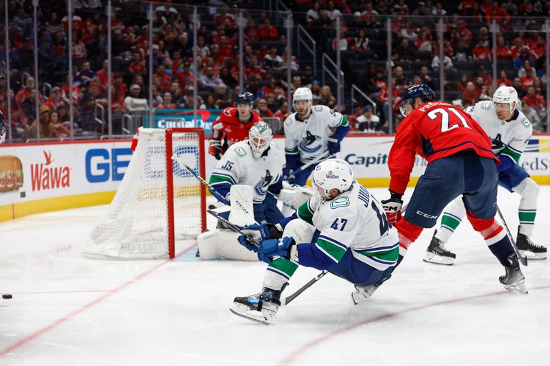 Feb 11, 2024; Washington, District of Columbia, USA; Vancouver Canucks defenseman Noah Juulsen (47) loses his balance while battling foe the puck with Washington Capitals center Aliaksei Protas (21) in the third period at Capital One Arena. Mandatory Credit: Geoff Burke-USA TODAY Sports