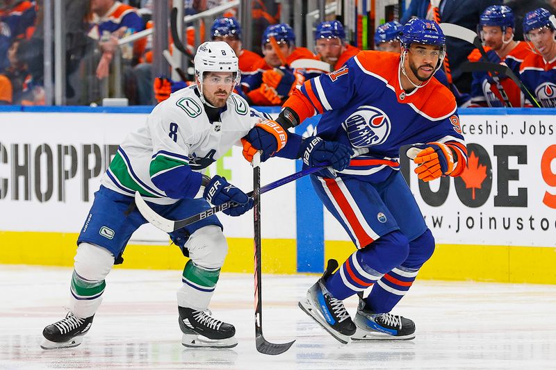Apr 13, 2024; Edmonton, Alberta, CAN; Vancouver Canucks forward Conor Garland (8) and Edmonton Oilers forward Evander Kane (91) looks for a loose puck during the first period at Rogers Place. Mandatory Credit: Perry Nelson-USA TODAY Sports