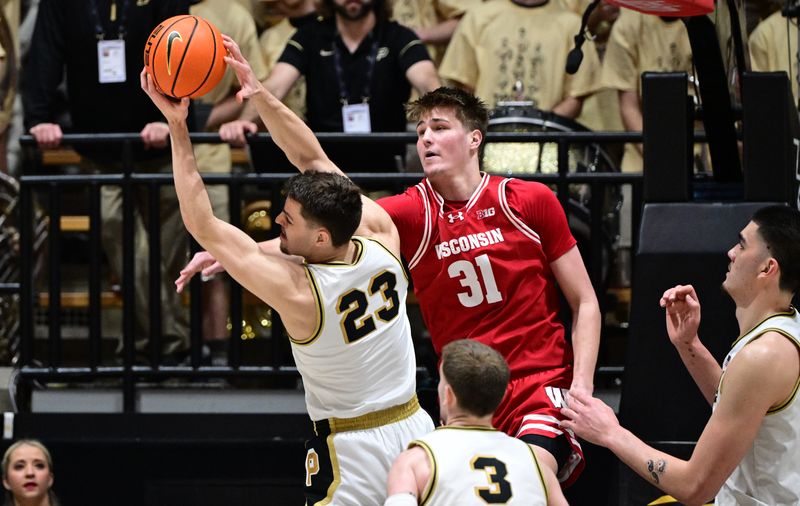 Mar 10, 2024; West Lafayette, Indiana, USA; Purdue Boilermakers forward Camden Heide (23) grabs a rebound away from Wisconsin Badgers guard Connor Essegian (3) during the second half at Mackey Arena. Mandatory Credit: Marc Lebryk-USA TODAY Sports