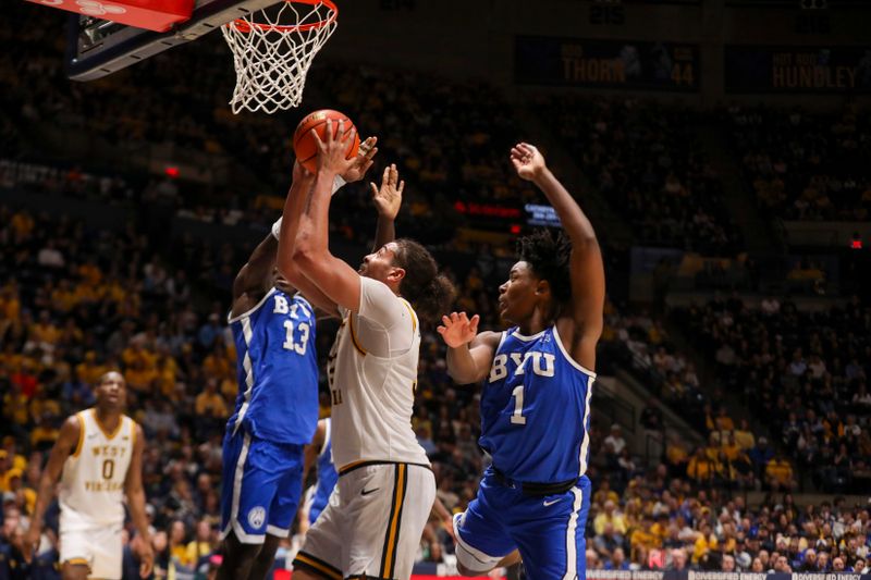Feb 28, 2026; Morgantown, West Virginia, USA; West Virginia Mountaineers center Harlan Obioha (55) rebounds the ball and shoots during the second half against the BYU Cougars at Hope Coliseum. Mandatory Credit: Ben Queen-Imagn Images